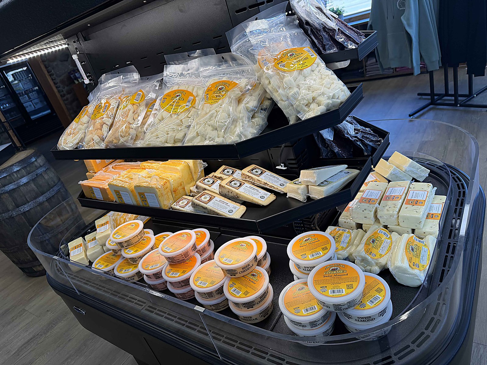 Glass-door cheese cooler stocked with Wisconsin cheese — Roth, Yodelay, Widmer, North Country, Alpine Lace, and more