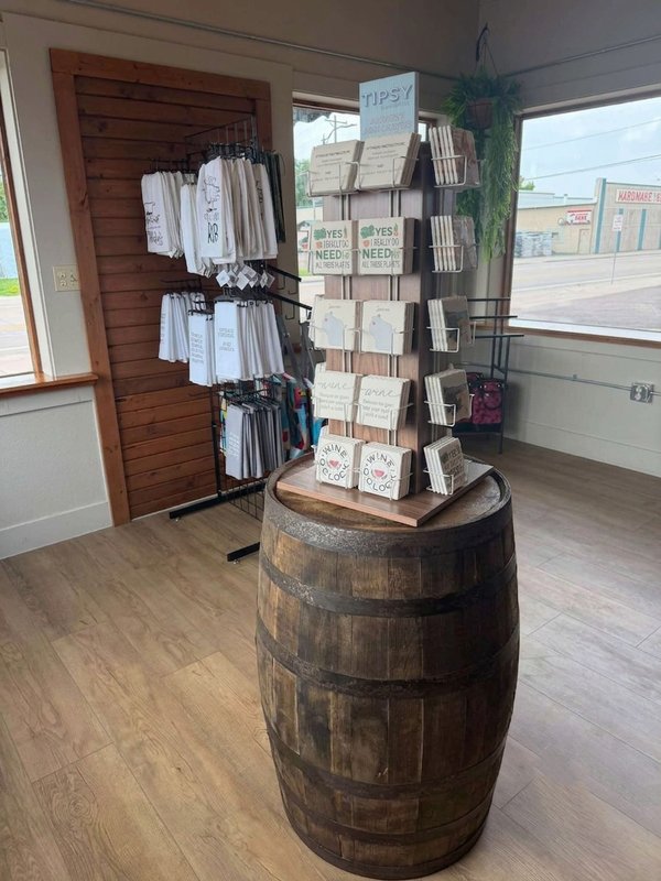Tipsy brand absorbent coasters displayed on a whiskey barrel at the Crossroads shop