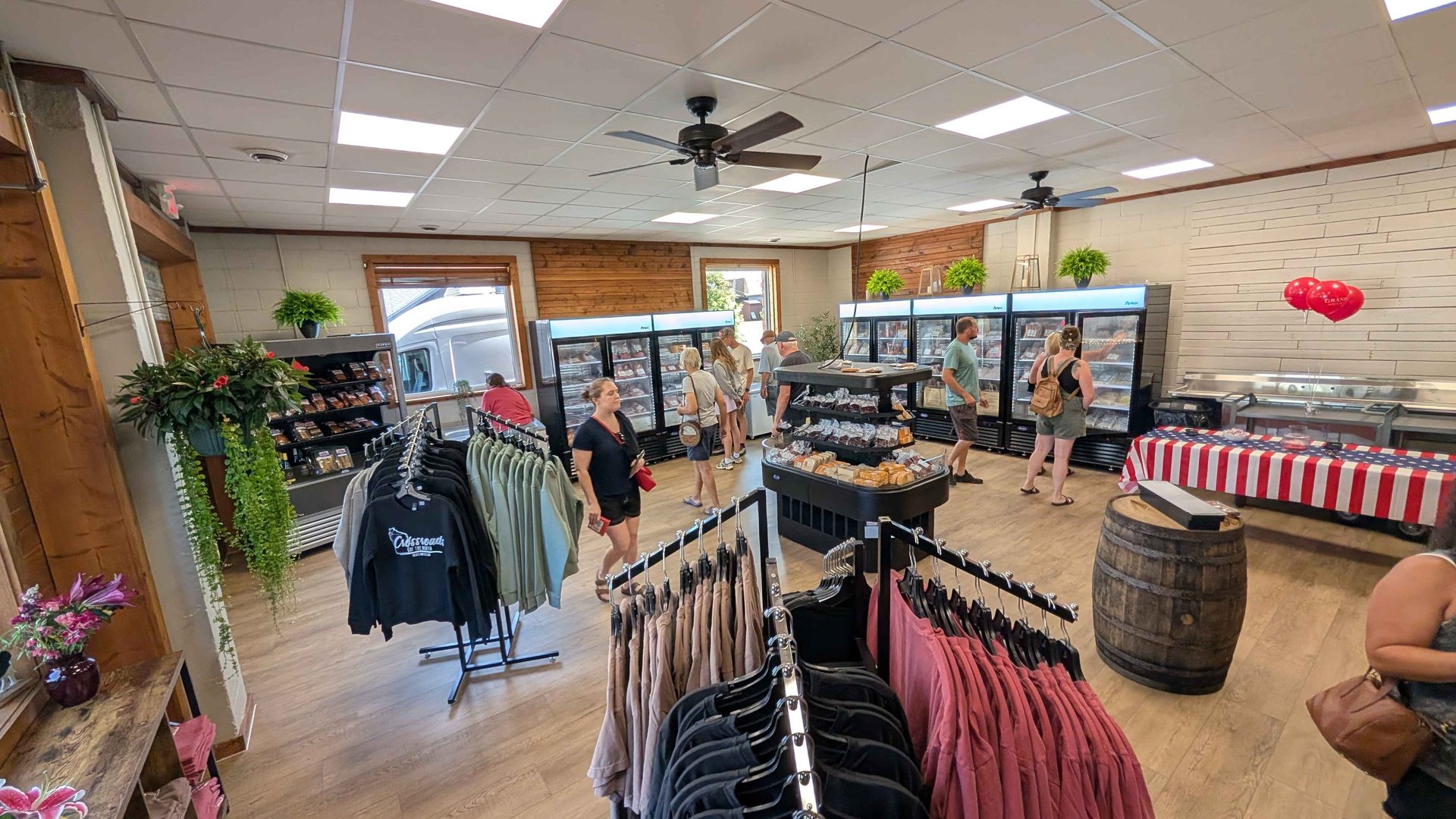 Full interior overview of Crossroads of the North — the full shop in one frame, coolers, cellar wall, and apparel racks